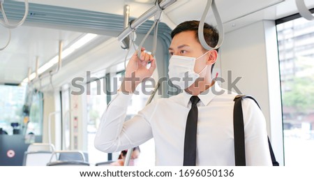 Similar – Image, Stock Photo Serious passengers in protective masks during their train trip