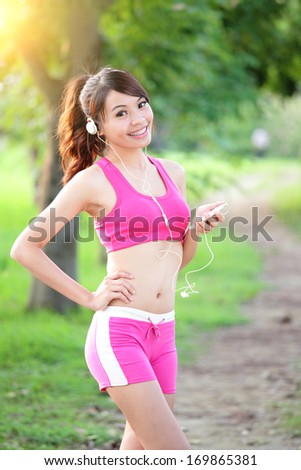 Running woman in park. Asian sport fitness model in sporty running clothes.