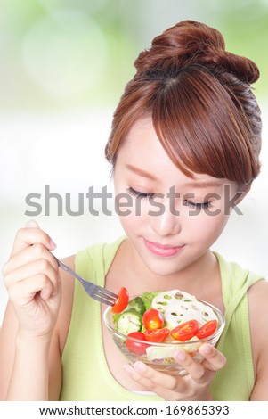 portrait of attractive woman smile eating salad isolated on green background, asian beauty model