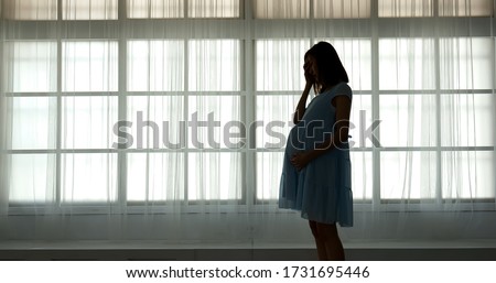 pregnant woman feel depression standing in front of window Imagine de stoc © 