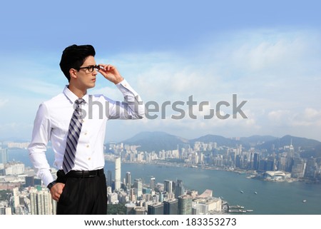 Successful handsome business man purposefully looking away with blue sky in the city