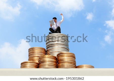 Successful business man working and using tablet pc on growth money stairs coin with sky