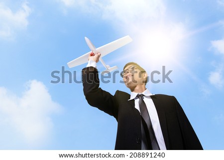I have a dream - Businessman holding airplane with sky background, asian