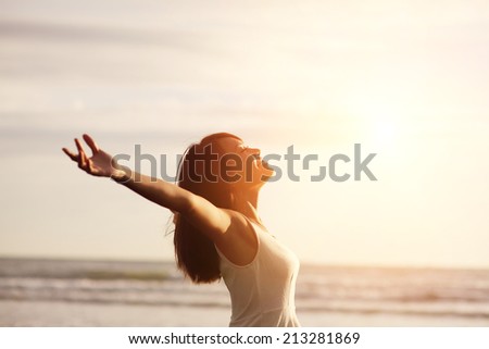 Smile Freedom and happiness woman on beach. She is enjoying serene ocean nature during travel holidays vacation outdoors. asian beauty