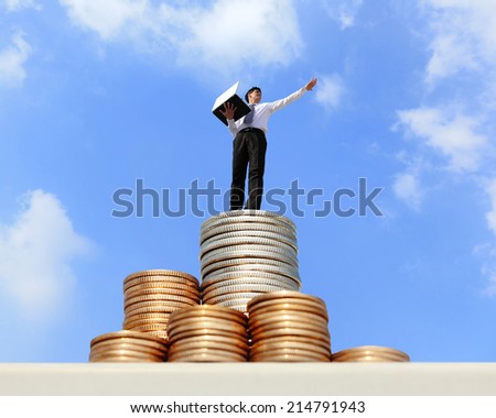 Successful business man working with computer on growth money stairs coin with sky