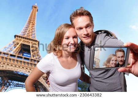 happy couple selfie by smart phone in Paris with eiffel tower, caucasian