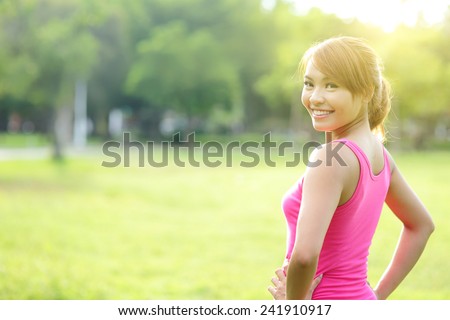 Young sport woman stretching and preparing to run in park. asian