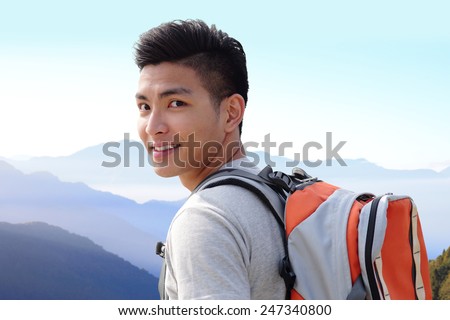 Successful man mountain hiker with backpack on the top of mountains. asian