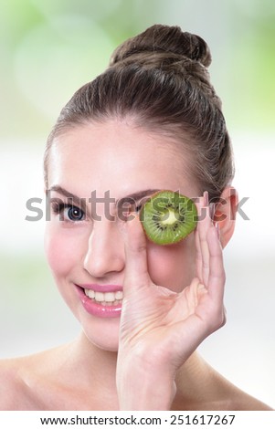 Kiwi is great for health - Healthy fruit funny woman holding kiwi fruit for her eyes, caucasian