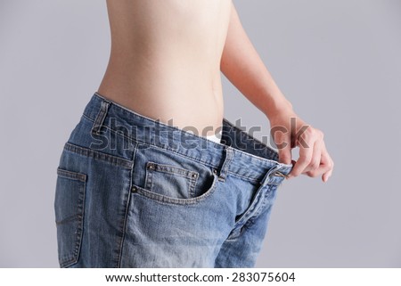 woman shows weight loss by wearing old jeans, asian beauty
