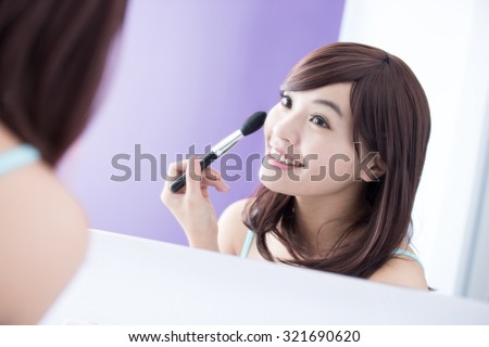 Close up of Smile woman with makeup brushes near face and look mirror. asian beauty