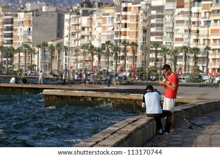 IZMIR, TURKEY - JUNE 26:  people fishing at Alsancak coastline in Izmir, June 26, 2005 in Izmir, Turkey. Izmir is the third most populous city in Turkey. This coastline public name is Kordon.