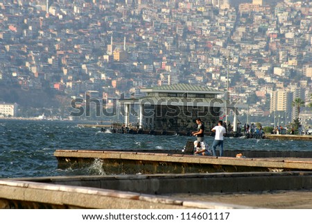 IZMIR, TURKEY - JUNE 26: People fishing at Alsancak coastline in Izmir, June 26, 2005 in Izmir, Turkey. Izmir is the third most populous city in Turkey. This line public name is Kordon.