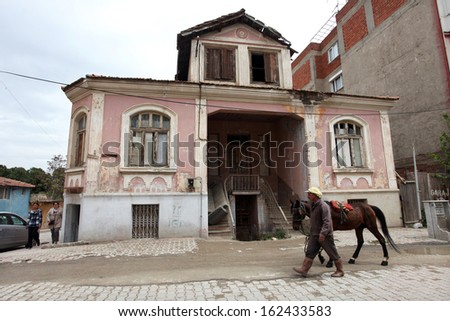 ALASEHIR, TURKEY - APRIL 27: Man and horse walking behind old building at ancient city of Alasehir on April 27, 2011 in Manisa, Turkey. Alasehir in antiquity and the middle ages known as Philadelphia.