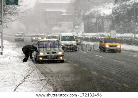 ISTANBUL, TURKEY - JANUARY 23: A man is repairing his car in snowy day at Eminonu District on January 23, 2007 in Istanbul, Turkey.
