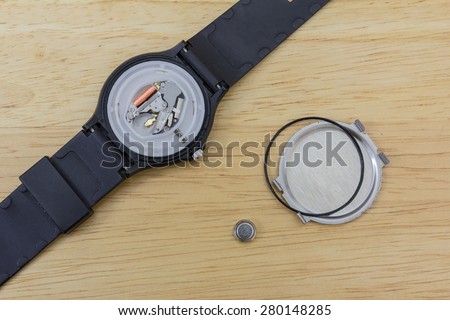 Inner parts of a wrist watch on a wooden table