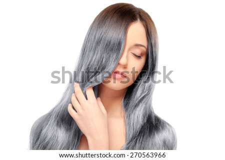 Fresh and beautiful. Portrait of beautiful young woman with closed eyes and holding hand on her long gray hair while standing against white background