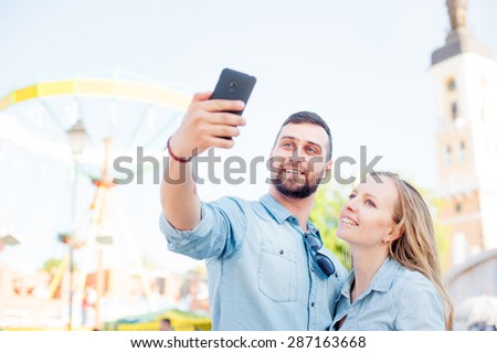 Catching the bright life moments. Beautiful young loving couple making selfie with smart phone and smiling while traveling by Europe.