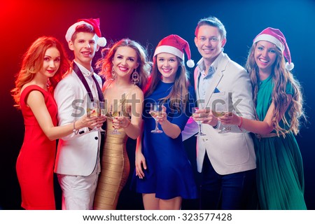 Merry Christmas and Happy New Year! Party and celebration. Group of six happy smiling friends having fun together in the nightclub.