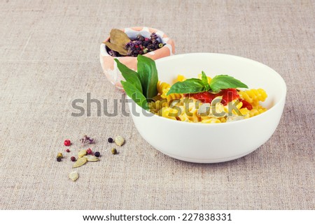 Fusilli pasta in a bowl with green basil and cheese. The culinary tradition of Italy. The second dish of pasta with cheese and tomato sauce