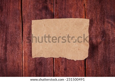 Piece of yellowed paper on the desk of the boards. Paper with space for text on the wooden table. Note on the table.