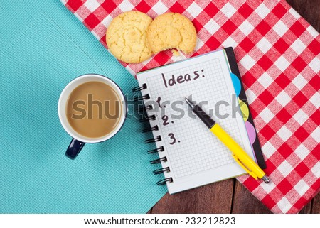 A cup of coffee with biscuits and a list of ideas in a notebook. The idea of coaching, motivation, coaching and achievement.