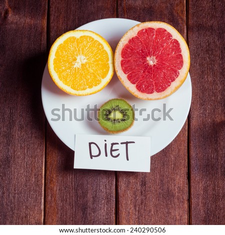 The concept of a fruit diet. Cut fruit on a white plate on the table. Losing excess weight on a strict fruit diet. Wellness and healthcare.