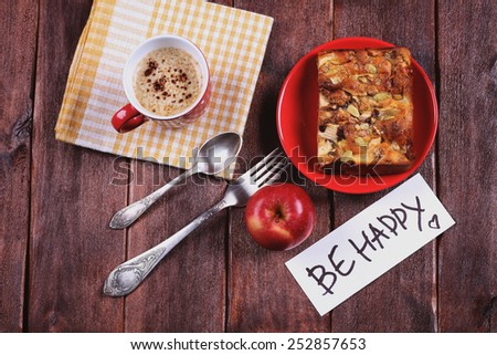 Apple pie and a cup of cappuccino. Cup on the table. Expression of feelings, the wish to be happy. Red apple pie and a cup of coffee. Top view. Space for text. The concept of  caring for someone.