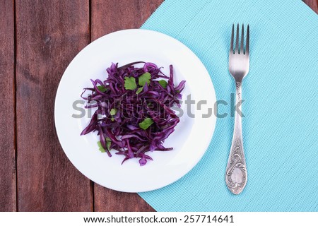 Salad of red cabbage. Diet food. Salad on a white plate, a top view, plate and fork on the table. Low-calorie salad.