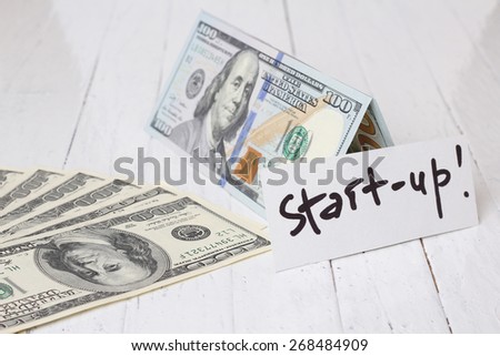 Money on the table. Idea, concept of start up. Hundred dollars. Banknotes on the table. A lot of dollars. The theme of the business, entrepreneurship, profit, start-up capital.
