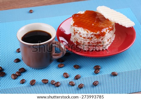 A delicious dessert. Lunch, snack. Cup of coffee on the table. A Cup of espresso. Refined sugar, coffee beans and waffles with jam. Waffles, covered in apricot jam.