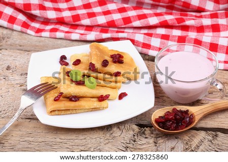 Dried berries and thin pancakes. To eat pancakes. A coffee shop, restaurant. Recipe pancakes. Closeup. Pancakes with mint and cranberries. Delicious Breakfast, lunch.