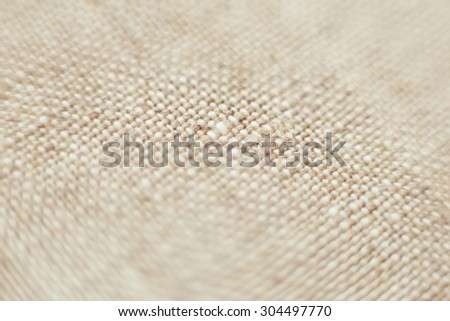 Light brown linen fabric. The background texture. Macro photo. Close-up, close. Beige cloth. Attic, a clothing store, tailoring. Business.
