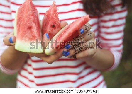 Chunks of watermelon in hands. Keep in hand. Food, diet, diet food. Girl with mehendi and blue nails. Three pieces of ripe juicy watermelon. Watermelon in hand.