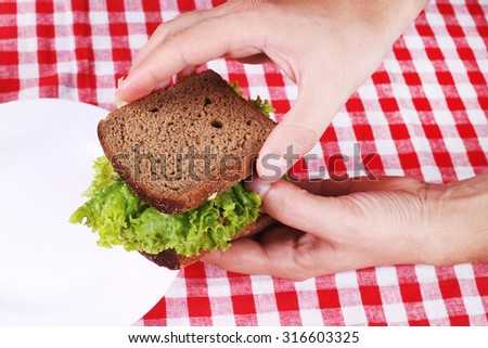 A man making a sandwich of rye bread and lettuce. Snack, breakfast, food, lunch. Tasty and healthy food.