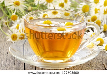 Herbal chamomile tea with chamomile flowers on wooden table