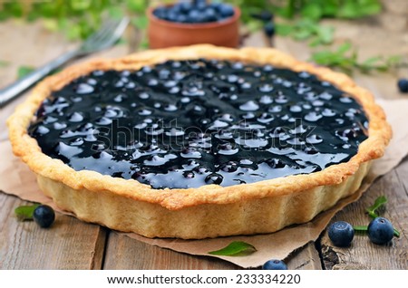 Blueberry pie and fresh berries on rustic wooden table, shallow depth of field