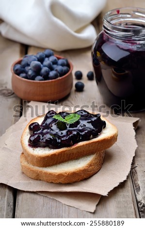 Blueberry jam on toast bread on wooden table