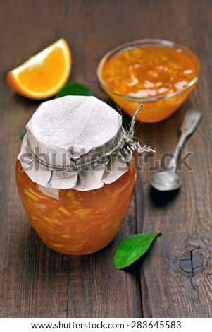 Orange jam in jar on wooden table