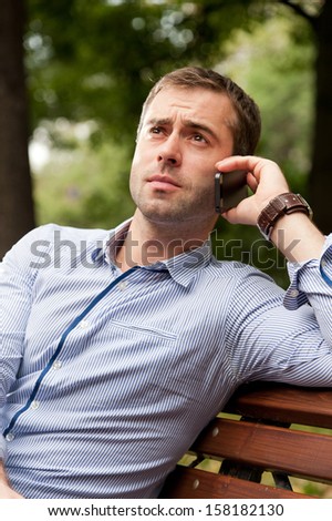 Man sits on the bench and relax in the public garden
