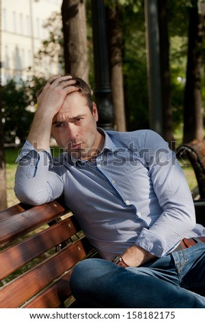 Man sits on the bench and relax in the public garden
