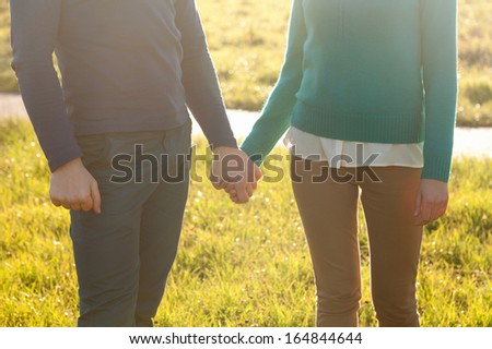 Couple Holding Hands in the Park at sunshine weather