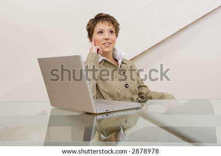 Business woman thinking in front of computer.