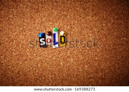 Sold   - Cut out letters pinned on a cork notice board.