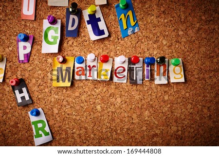 Marketing - Cut out letters pinned on a cork notice board.