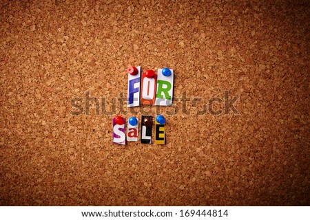 For sale - Cut out letters pinned on a cork notice board.
