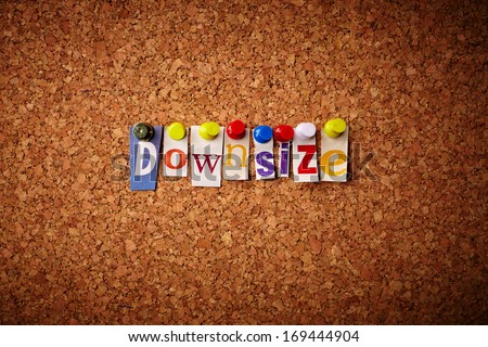 Downsize - Cut out letters pinned on a cork notice board.