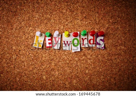 Keywords - Cut out letters pinned on a cork notice board.
