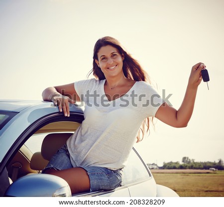 Driver girl -Happy smiling woman is showing keys to her new car, rental car.