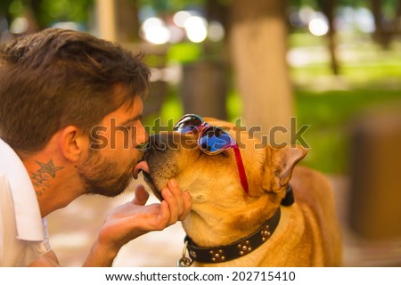 dog in eyeglasses with a male model. Kissing